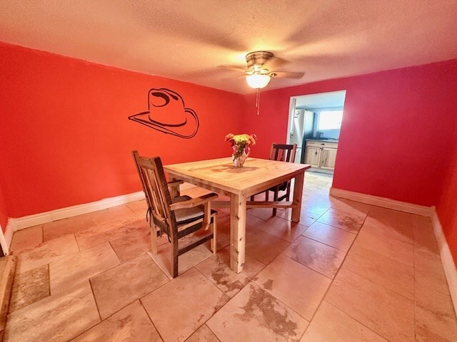 dining area featuring a textured ceiling and ceiling fan