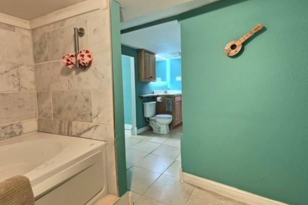 bathroom featuring a tub, tile patterned flooring, and toilet