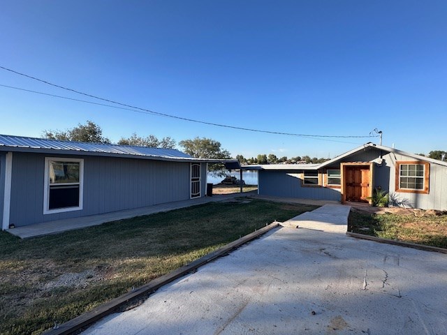 view of side of home with a patio area and a yard