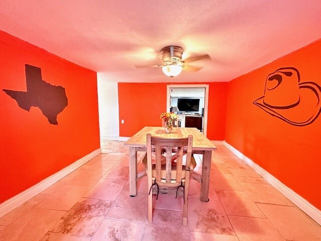 dining space with a textured ceiling and ceiling fan