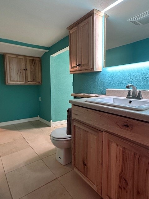 bathroom featuring tile patterned flooring, vanity, and toilet