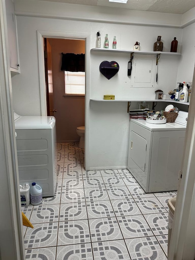 clothes washing area featuring washer and clothes dryer, light tile patterned floors, and cabinet space