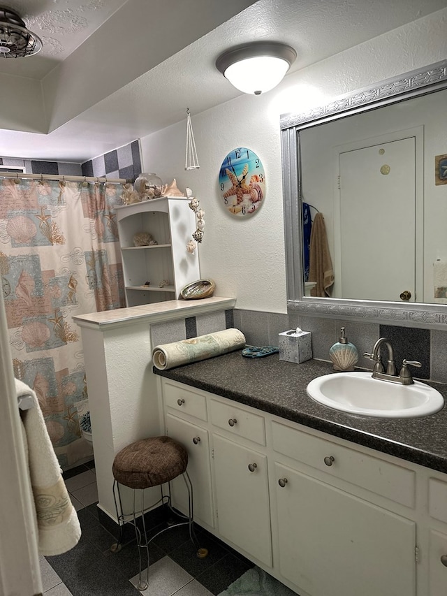 bathroom featuring tile patterned flooring, backsplash, a textured ceiling, vanity, and a shower with shower curtain