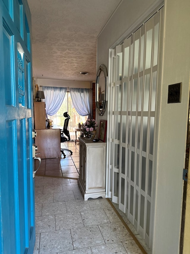 foyer featuring stone tile floors and a textured ceiling