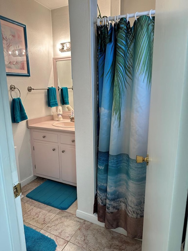 full bathroom featuring vanity, a shower with shower curtain, and baseboards