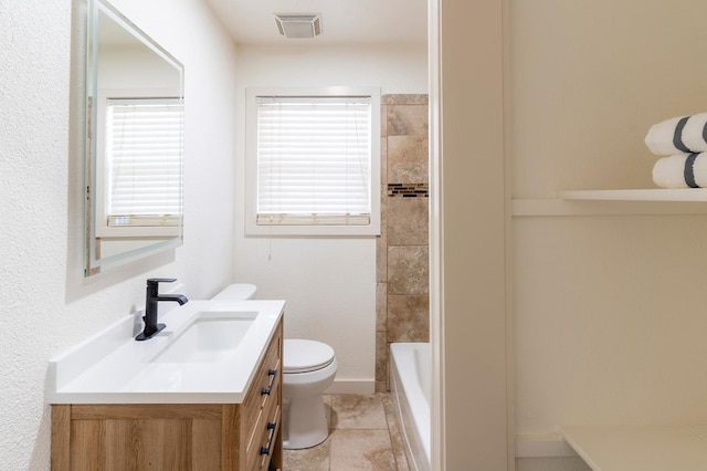 bathroom featuring toilet, baseboards, visible vents, and vanity