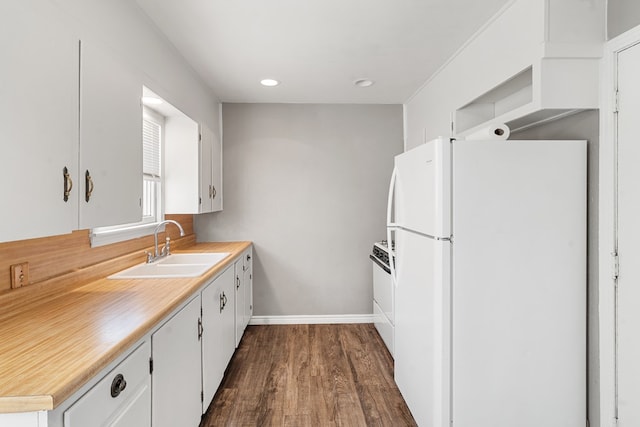 kitchen featuring light countertops, dark wood-type flooring, white cabinets, a sink, and white appliances