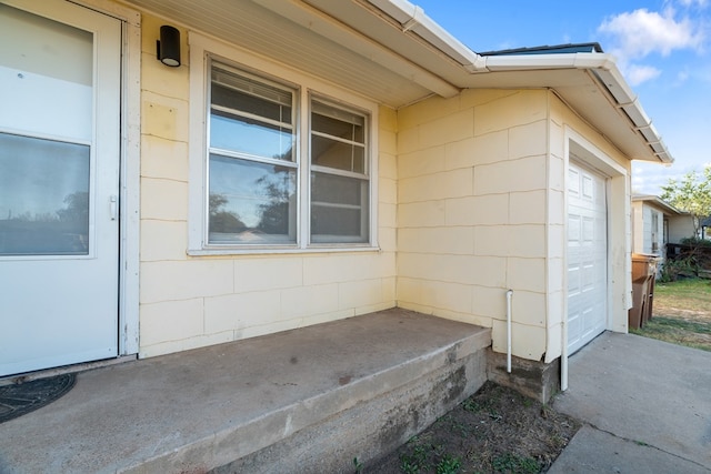 exterior space with a garage and concrete block siding