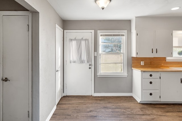 entryway with dark wood-type flooring and baseboards