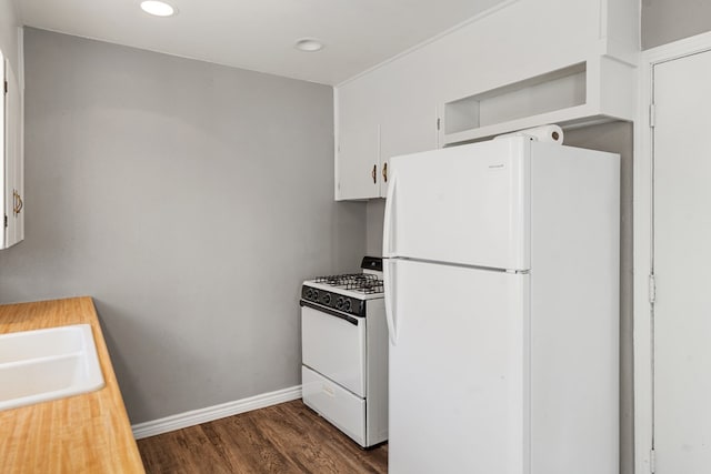 kitchen with white appliances, white cabinetry, dark wood-type flooring, and a sink