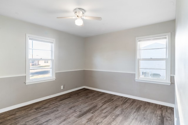 empty room with dark wood-type flooring, baseboards, and a ceiling fan