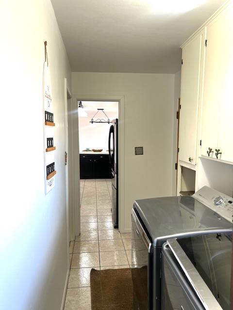 washroom with light tile patterned flooring, cabinets, and independent washer and dryer