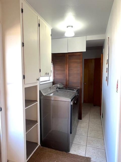 washroom featuring cabinets, light tile patterned floors, and washing machine and dryer