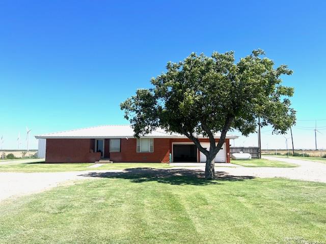 ranch-style house with a garage and a front lawn