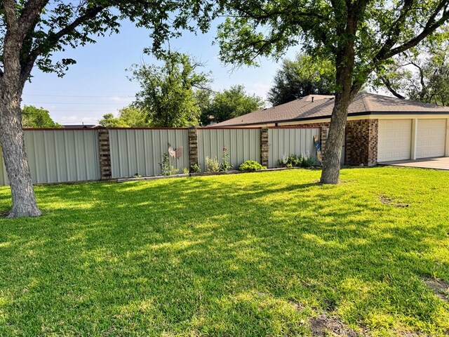 1512 W 14th St, Fort Stockton, TX 79735 - view of grassy yard with a garage and concrete driveway