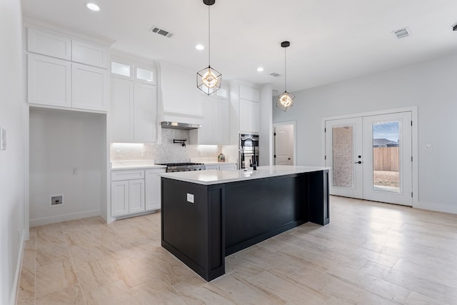 kitchen featuring pendant lighting, an island with sink, white cabinets, and premium range hood