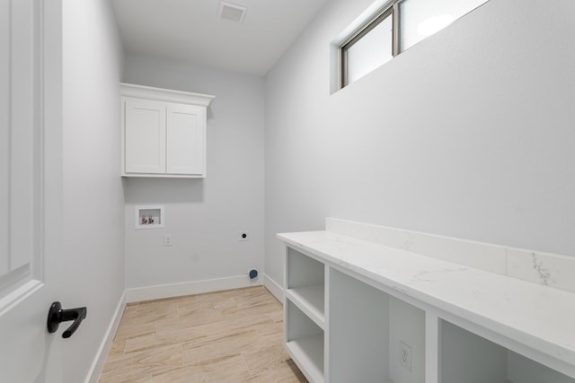 clothes washing area with cabinets, hookup for an electric dryer, and hookup for a washing machine