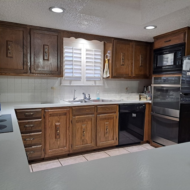 kitchen featuring black appliances, decorative backsplash, light tile patterned flooring, and sink