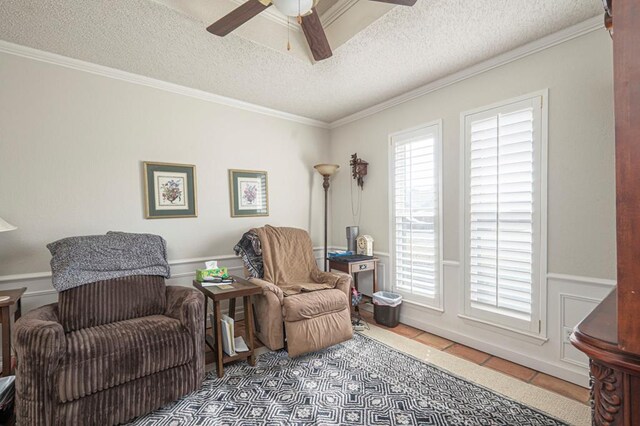 4704 Elma Dr, Midland, TX 79707 - living area with a textured ceiling, ceiling fan, wainscoting, tile patterned floors, and crown molding