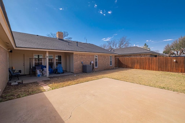 4704 Elma Dr, Midland, TX 79707 - rear view of property featuring a patio area, a chimney, cooling unit, a shingled roof, and brick siding