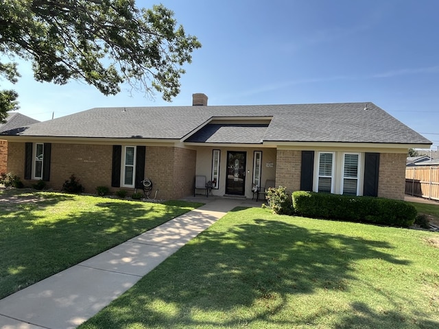 4704 Elma Dr, Midland, TX 79707 - view of front of house featuring brick siding, a front yard, a shingled roof, and a chimney
