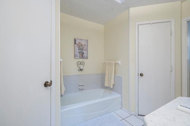 4704 Elma Dr, Midland, TX 79707 - bathroom with tile patterned floors, a garden tub, a textured ceiling, and vanity