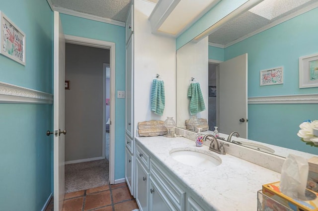 4704 Elma Dr, Midland, TX 79707 - bathroom featuring vanity, a textured ceiling, crown molding, tile patterned flooring, and baseboards