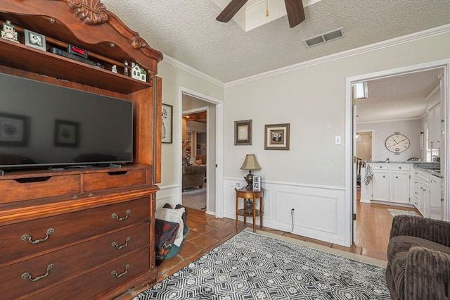4704 Elma Dr, Midland, TX 79707 - living room featuring a textured ceiling, ceiling fan, crown molding, wainscoting, and tile patterned flooring
