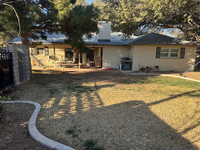 rear view of house with a yard and a patio area