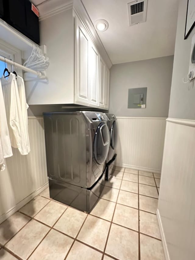 laundry area with cabinets, washing machine and dryer, light tile patterned floors, and electric panel