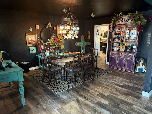 dining room featuring baseboards, an inviting chandelier, and wood finished floors