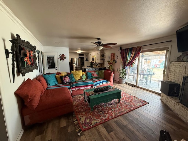 living room with a textured ceiling, wood finished floors, and a ceiling fan