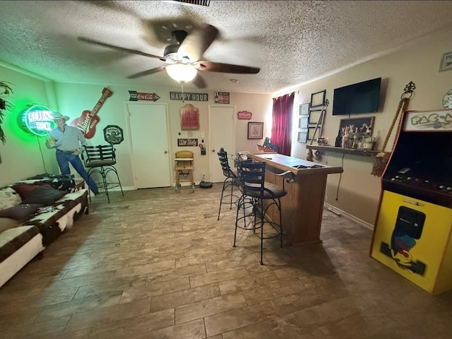 bar with a textured ceiling, a bar, and a ceiling fan