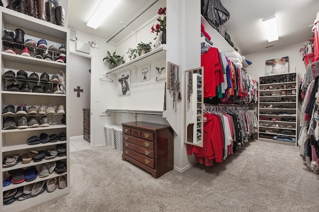 walk in closet featuring light carpet