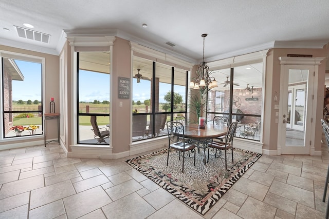 dining room featuring ornamental molding, a textured ceiling, and an inviting chandelier