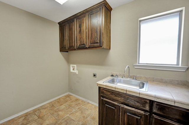 washroom with baseboards, hookup for a washing machine, cabinet space, hookup for an electric dryer, and a sink