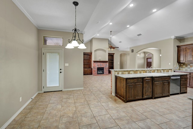 kitchen with a sink, a ceiling fan, a brick fireplace, and crown molding