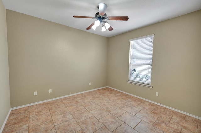 empty room featuring light tile patterned floors, a ceiling fan, and baseboards