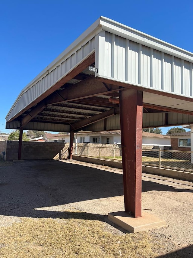 view of parking featuring a carport and fence