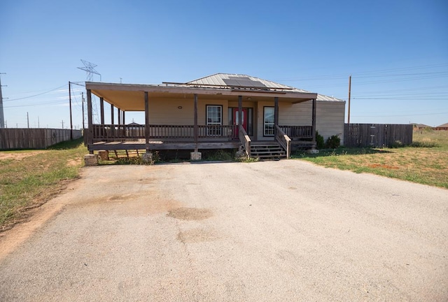 view of front facade featuring a porch and solar panels