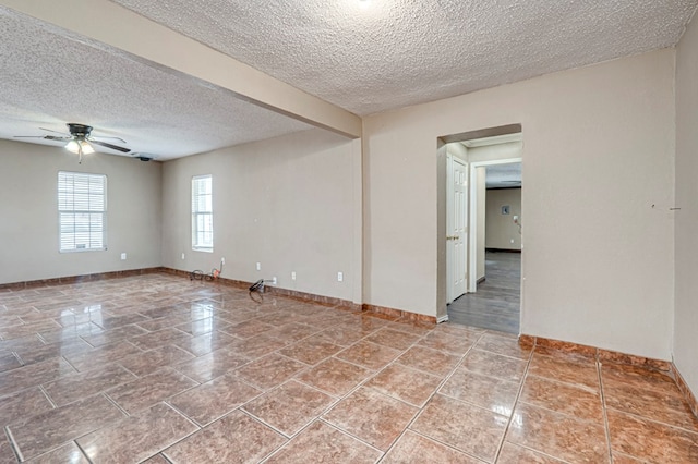 3608 S County Rd 1195, Midland, TX 79706 - tiled empty room featuring a textured ceiling, ceiling fan, and baseboards