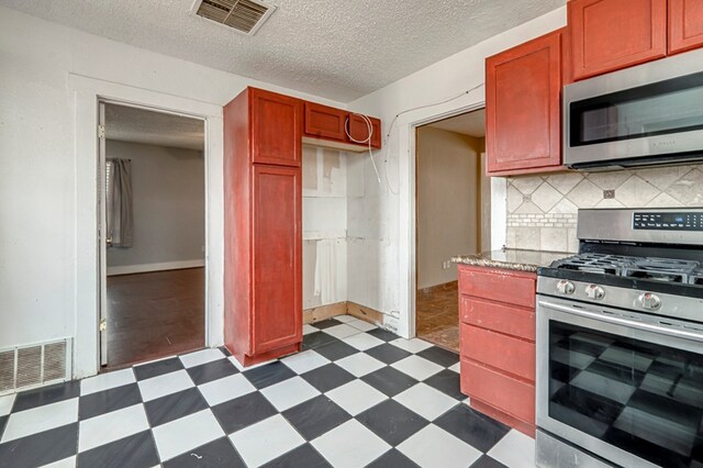 3608 S County Rd 1195, Midland, TX 79706 - kitchen with appliances with stainless steel finishes, dark floors, tasteful backsplash, dark brown cabinets, and a textured ceiling