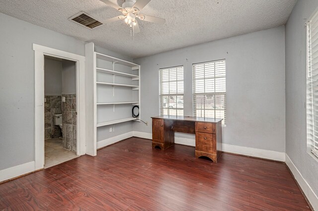3608 S County Rd 1195, Midland, TX 79706 - unfurnished bedroom featuring dark wood-style flooring, a textured ceiling, baseboards, and a ceiling fan