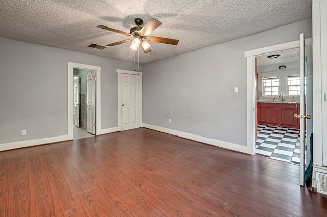 3608 S County Rd 1195, Midland, TX 79706 - unfurnished room with ceiling fan, dark wood finished floors, a textured ceiling, and baseboards