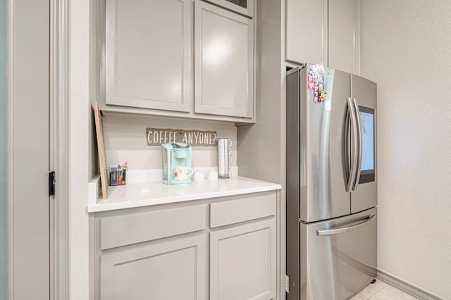 kitchen featuring light tile patterned flooring and stainless steel refrigerator