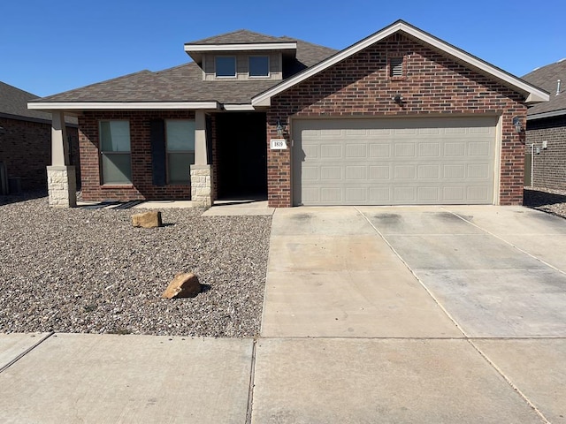 view of front of property featuring driveway, brick siding, an attached garage, and a shingled roof