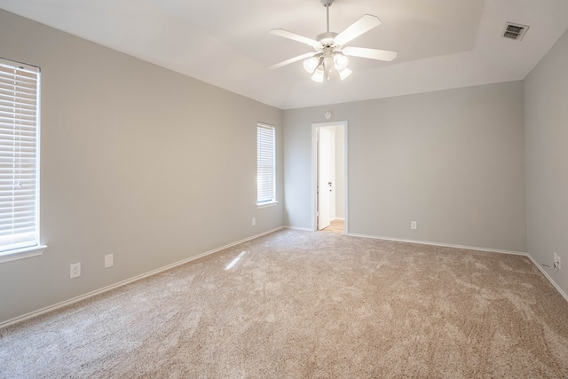 unfurnished room featuring light carpet, ceiling fan, visible vents, and baseboards