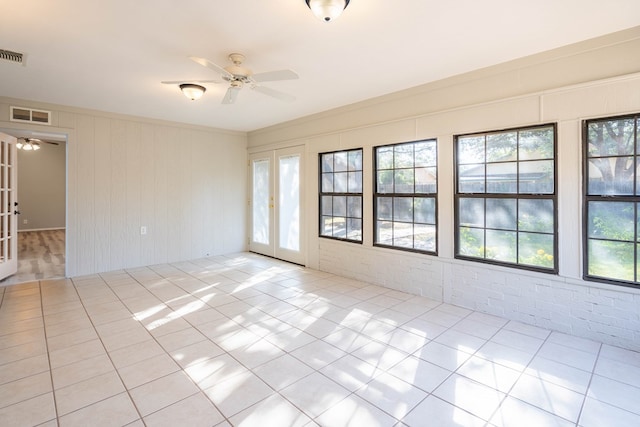 unfurnished room with ceiling fan, french doors, a wealth of natural light, and visible vents