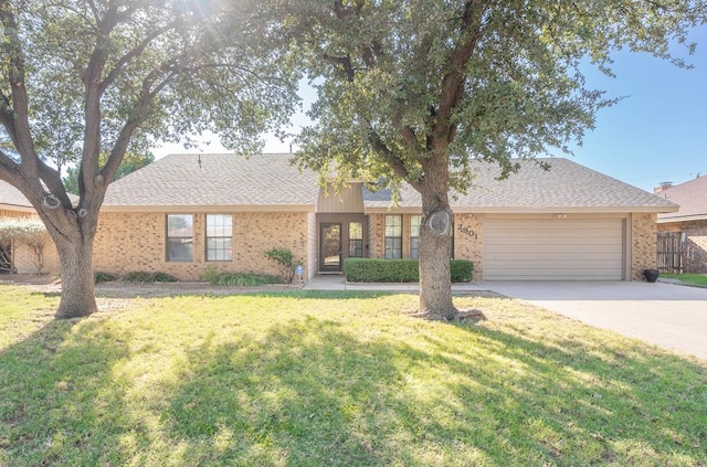 ranch-style house featuring brick siding, roof with shingles, concrete driveway, a front yard, and a garage