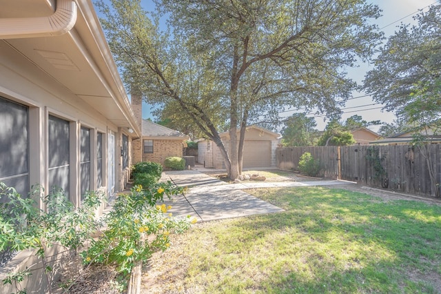 view of yard featuring a patio area, a fenced backyard, and an outdoor structure